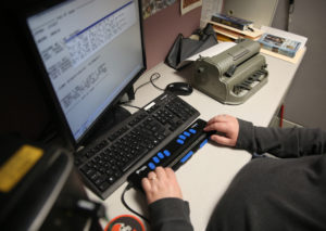 Clovernook Center employee uses refreshable braille display to transcribe text.